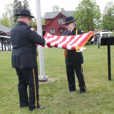 Ceremony over, Honor Guard members Rodney Carlson and Sue Westerlind retire the flag. Photo by Rhonda Silence