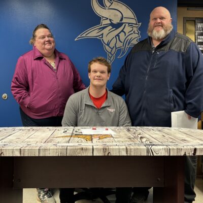 Cade Smith signing letter of intent with parents | Photo by Michael McHugh